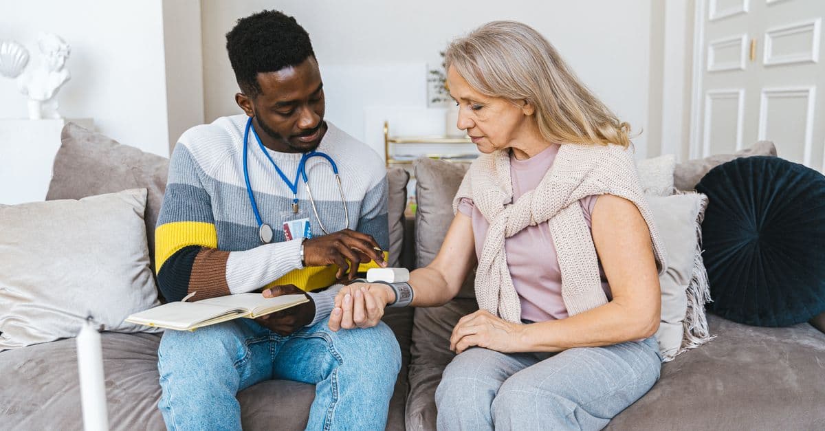 An assessor talking with an older person at their kitchen table