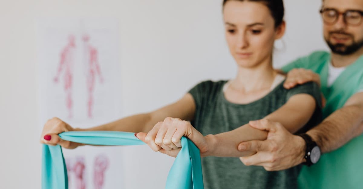 A physiotherapist guiding a resistance-band exercise