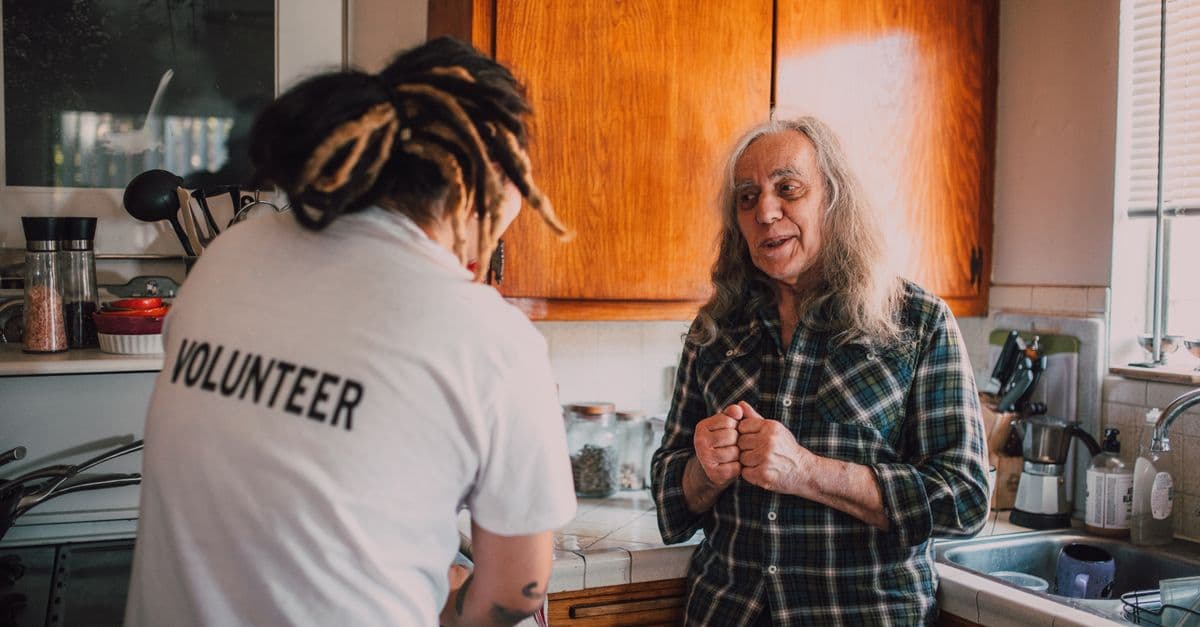 A home care worker helping an older person in their own kitchen