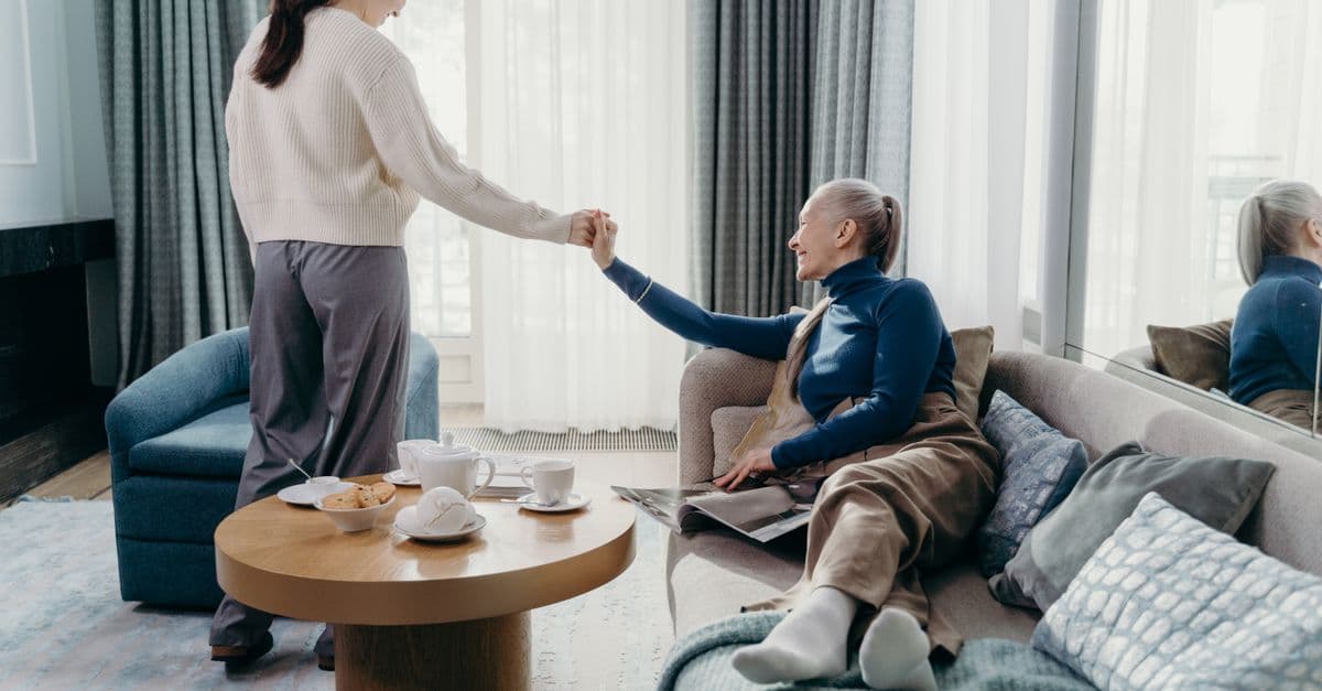 An adult child spending time with their older parent at home