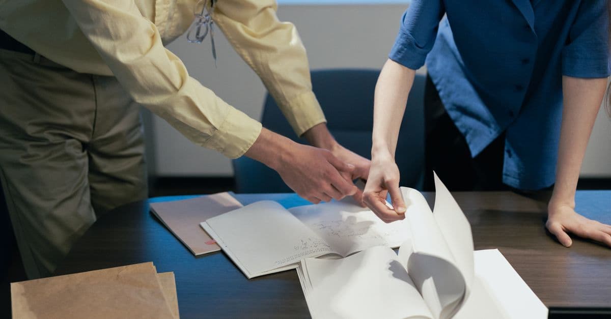 Two people reviewing plan documents at a meeting