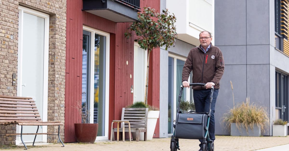 An older man out walking with a mobility aid during recovery