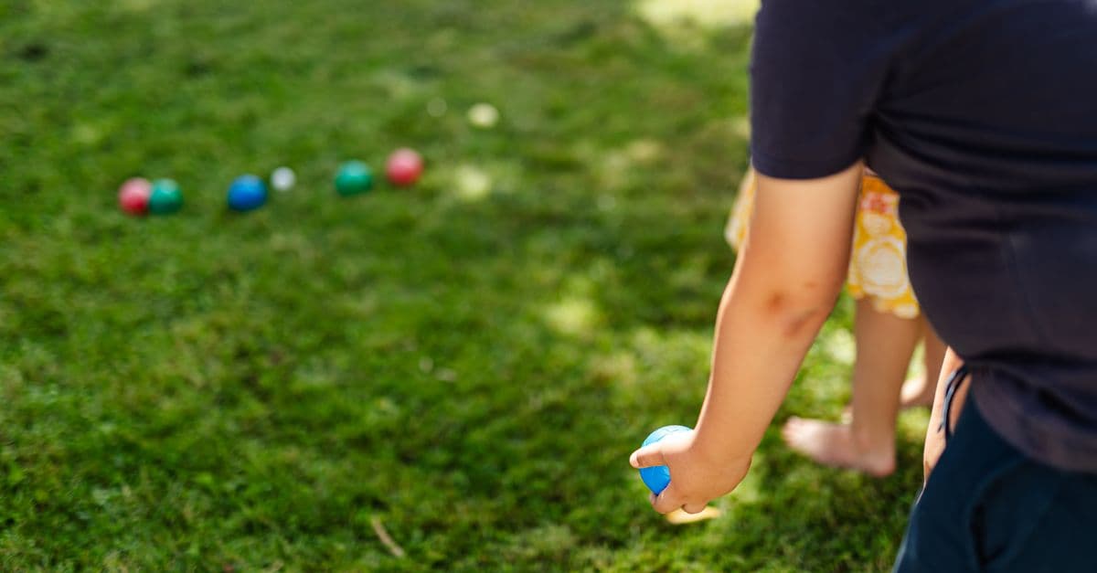 Coloured bowls resting on the grass beside the jack