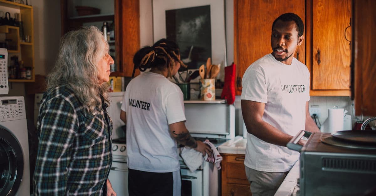 A volunteer bringing a meal to an older person at home