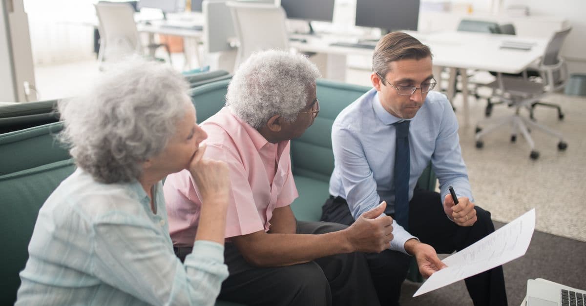An older couple reviewing documents with an adviser