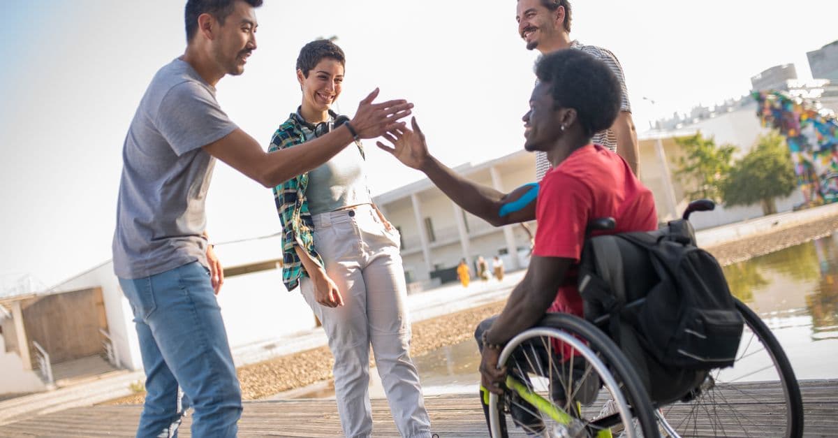 A support worker and a person using a wheelchair out together